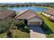 Single-story home with tile roof, lakefront view, and landscaped yard at 6517 Willowshire Way, Bradenton, FL 34212