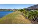 Lakefront backyard with lush landscaping and screened enclosure at 6517 Willowshire Way, Bradenton, FL 34212