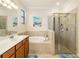 Bathroom featuring a tiled shower, soaking tub, and vanity with dual sinks at 6517 Willowshire Way, Bradenton, FL 34212