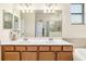 Bathroom vanity with double sinks, large mirror, and a view into the shower and tub area at 6517 Willowshire Way, Bradenton, FL 34212