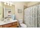 Well-lit bathroom featuring a vanity with a white countertop and decorative shower curtain at 6517 Willowshire Way, Bradenton, FL 34212