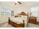 Comfortable bedroom with a decorative wood bed frame and natural light from large windows at 6517 Willowshire Way, Bradenton, FL 34212