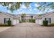 Inviting condo exterior with garages, lush landscaping, and a staircase to upper units at 905 Addington Ct # 203, Venice, FL 34293