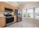 Kitchen boasts stainless steel appliances and wood cabinets at 905 Addington Ct # 203, Venice, FL 34293