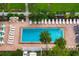 Aerial view of a refreshing community pool with tables, chairs and surrounding greenery at 905 Addington Ct # 203, Venice, FL 34293
