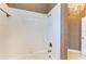 Clean bathroom with white tile, built-in shelving, and bathtub at 9750 53Rd E Dr, Bradenton, FL 34211