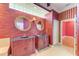 Bathroom with double sinks, large mirrors, and decorative wallpaper at 9750 53Rd E Dr, Bradenton, FL 34211
