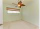 Spacious bedroom with ceiling fan, large window, and neutral carpeting at 9750 53Rd E Dr, Bradenton, FL 34211