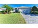 Single-story home with gray exterior, two-car garage, and landscaped lawn at 9750 53Rd E Dr, Bradenton, FL 34211