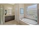 Elegant bathroom with a soaking tub, walk-in shower, and dark wood vanity at 1014 Overlook Ct, Bradenton, FL 34208
