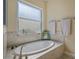 Bathroom with oval soaking tub and neutral tile at 1014 Overlook Ct, Bradenton, FL 34208