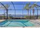 Enclosed pool area with water view and lush tropical landscaping at 1014 Overlook Ct, Bradenton, FL 34208