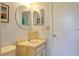 Small bathroom with a vanity and round mirror at 11058 Deerwood Ave, Englewood, FL 34224