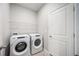 Convenient laundry room with washer and dryer and overhead storage at 12689 Promenade Estates Blvd, Sarasota, FL 34238