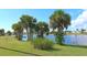 Lakeside view with lush grass and palm trees at 13368 Englewood Rd, Port Charlotte, FL 33981