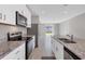 Modern kitchen with white cabinets, granite counters, and stainless steel appliances at 148 Whiteland Bnd, Nokomis, FL 34275