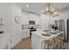 Modern kitchen with white cabinets, quartz countertops and island with seating at 1496 Sunset Preserve Way, Port Charlotte, FL 33953