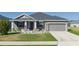 Gray house with white columns, gray roof, and landscaping at 16128 67Th E Ct, Parrish, FL 34219