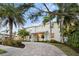 Two-story house with a light gray exterior, palm trees, and a curved driveway at 1815 Grove St, Sarasota, FL 34239