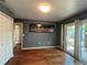 Bedroom features wood floors, gray walls, closet, and sliding glass doors to backyard at 2072 Misty Sunrise Trl, Sarasota, FL 34240