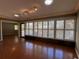 Bright living room features plantation shutters, hardwood floors, and natural light from surrounding windows at 2072 Misty Sunrise Trl, Sarasota, FL 34240