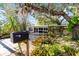 Mature trees and tropical plants grace the home's entrance at 2207 Hickory Ave, Sarasota, FL 34234