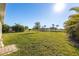 Spacious backyard with lush grass, water view, and tropical plants at 28214 Arrowhead Cir, Punta Gorda, FL 33982