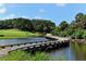 Wooden bridge over water at golf course leads to green at 401 Walls Way, Osprey, FL 34229