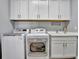 Laundry room with white cabinets and a utility sink at 5403 Tidewater Preserve Blvd, Bradenton, FL 34208