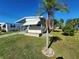 Mobile home with carport, landscaped lawn, and palm tree at 615 50Th Avenue W Ter, Bradenton, FL 34207