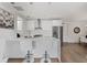 Modern white kitchen with island, stainless steel appliances, and breakfast bar at 635 S Orange Ave # 201, Sarasota, FL 34236