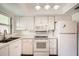 White kitchen with stainless steel appliances and gold fixtures at 665 Park Cir # 58, Bradenton, FL 34207