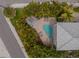 Aerial view of a home with a pool and lush landscaping at 796 Jacaranda Rd, Anna Maria, FL 34216