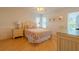 Cozy bedroom with a queen-size bed, light wood floors, and a desk at 796 Jacaranda Rd, Anna Maria, FL 34216