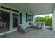 Covered deck features comfy seating and sliding glass door access at 796 Jacaranda Rd, Anna Maria, FL 34216