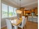 Bright dining area with a wood table, white chairs, and a view to the kitchen at 796 Jacaranda Rd, Anna Maria, FL 34216