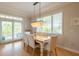 Casual dining area with a wooden table, white chairs, and access to a balcony at 796 Jacaranda Rd, Anna Maria, FL 34216