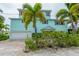 Two-story light teal home with white garage doors at 796 Jacaranda Rd, Anna Maria, FL 34216