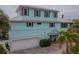 Two-story light teal home with white garage doors at 796 Jacaranda Rd, Anna Maria, FL 34216