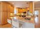 Modern kitchen with granite island, stainless steel appliances, and light wood cabinets at 796 Jacaranda Rd, Anna Maria, FL 34216