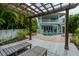 Relaxing pergola with lounge chairs and view of pool and home at 796 Jacaranda Rd, Anna Maria, FL 34216