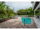 Relaxing kidney-shaped pool with surrounding patio and lush landscaping at 796 Jacaranda Rd, Anna Maria, FL 34216