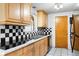 Kitchen featuring wood cabinets and black and white checkered backsplash at 801 Church St, Nokomis, FL 34275
