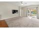 Living room with carpeting, sliding glass doors to backyard, and a ceiling fan at 15230 Searobbin Dr, Lakewood Ranch, FL 34202