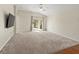 Spacious living room with carpeting, sliding doors, and a ceiling fan at 15230 Searobbin Dr, Lakewood Ranch, FL 34202
