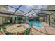 Covered patio with dining table and chairs overlooking the refreshing pool at 1598 Oak N Cir, Sarasota, FL 34232