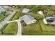 Aerial view of a home with solar panels on the roof, a driveway, and lush green lawn at 2545 Geneva Rd, Venice, FL 34293