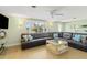 Living room with large leather sectional sofa, glass-top coffee table, and plantation shutters at 2545 Geneva Rd, Venice, FL 34293