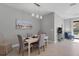 Bright dining room with white table and gray chairs, near the living room at 364 Palmaria Ct, Nokomis, FL 34275
