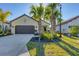 House exterior with a dark brown garage door and lush green landscaping at 364 Palmaria Ct, Nokomis, FL 34275